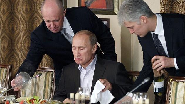 Ihm vertraut der mächtige Präsident: Jewgeni Prigoschin (l.) bedient Wladimir Putin (M.), daneben ein Bediensteter. Ihm vertraut der mächtige Präsident: Jewgeni Prigoschin (l.) bedient Wladimir Putin (M.), daneben ein Bediensteter.