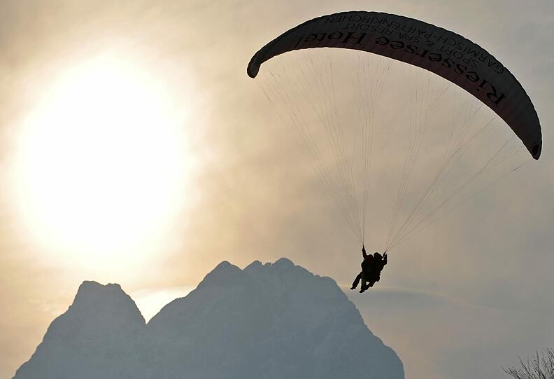 Auch in Bayern wußte man das eiskalte, aber immerhin Sonnen beschienene Wochenende zu nutzen: Ein Paraglider schwebt vor den Bergen bei Garmisch-Partenkirchen (Oberbayern) bei minus 15 Grad am Himmel.
