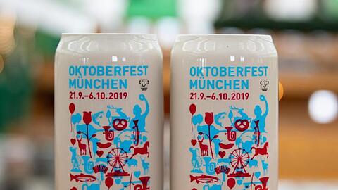 Name und Zeitraum des Oktoberfestes 2019 stehen auf zwei Examplaren des offiziellen Wiesn-Maßkrugs. Foto: Sven Hoppe/Archiv