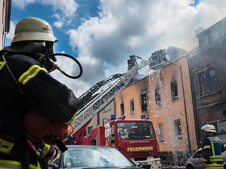 Einsatzkräfte der Feuerwehr löschen den Brand in dem Mehrfamilienhaus in Neunkirchen.