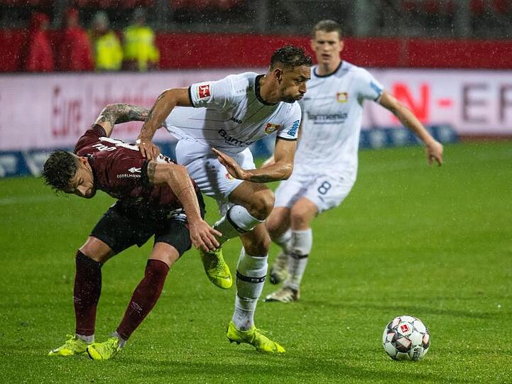Nürnbergs Tim Leibold (l) Bayer-Profi Karim Bellarabi in den Weg.