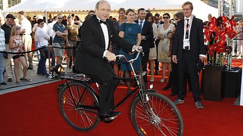 Der Dirigent Iván Fischer - hier mit dem Fahrrad vor dem Konzerthaus am Berliner Gendarmenmarkt. (Archivbild)