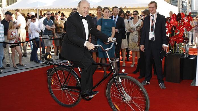 Der Dirigent Iván Fischer - hier mit dem Fahrrad vor dem Konzerthaus am Berliner Gendarmenmarkt. (Archivbild)