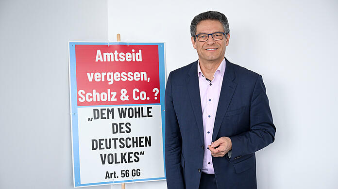 Wolfgang Wiehle ist einer von zehn bayerischen AfD-Abgeordneten. Er tritt im Münchner Süden an. Das Schild hatte er bei einer Demo dabei. Noch mehr stehen in seinem Büro.