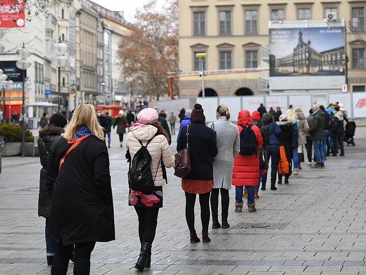 Geduldig mit Abstand in der Schlange: Diese hier führt in einem 90-Grad-Winkel vor der Alten Akademie zu einem Bekleidungsgeschäft.