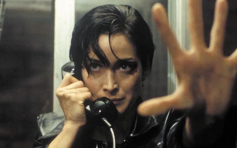 Trinity (Carrie-Anne Moss) nimmt den Ausgang aus der Matrix: eine öffentliche Telefonzelle. Trinity (Carrie-Anne Moss) nimmt den Ausgang aus der Matrix: eine öffentliche Telefonzelle.