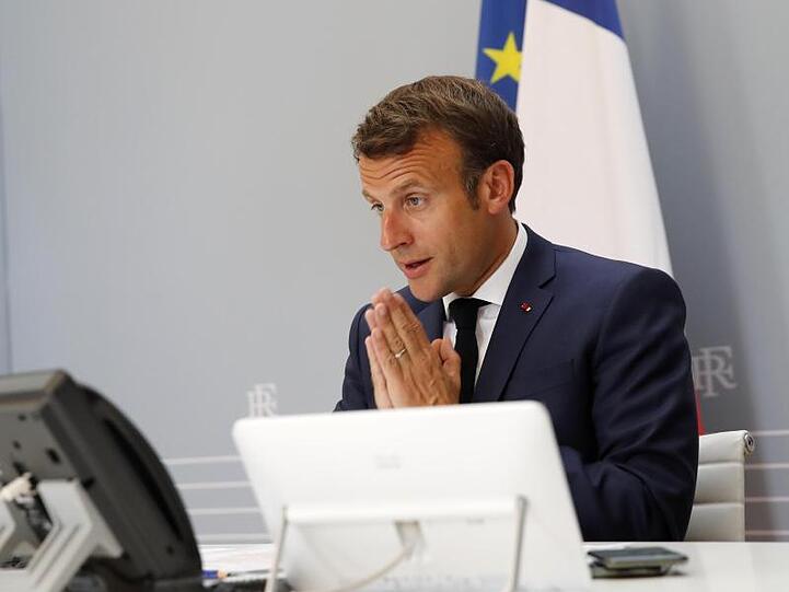 Emmanuel Macron nimmt aus dem Elysee-Palast heraus gestenreich an der WHO-Videokonferenz teil.