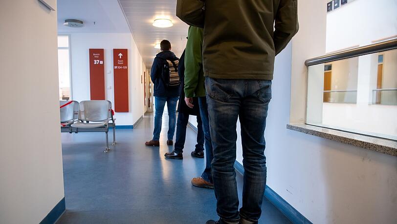 Menschen stehen in der Wartezone für Kirchenaustritte beim Standesamt München Schlange.