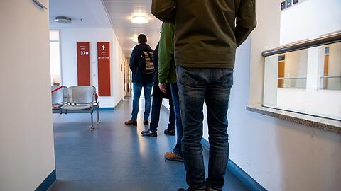 Menschen stehen in der Wartezone für Kirchenaustritte beim Standesamt München Schlange.