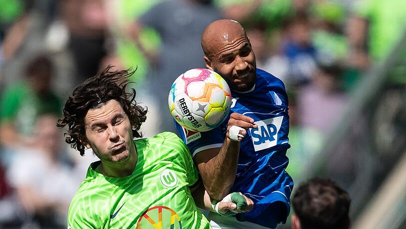 Wolfsburgs Jonas Wind (l) und John Anthony Brooks von der TSG 1899 Hoffenheim kämpfen um den Ball.