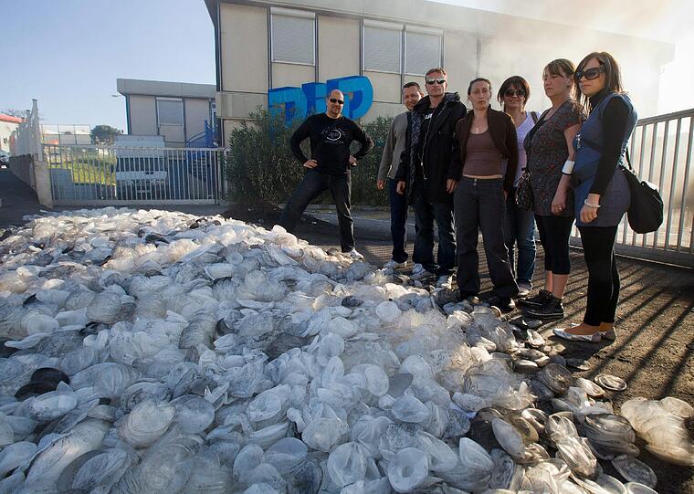 Arbeiter des Unternehmens PIP (Poly ImplantProthese) stehen am 10.04.2010 in La Seyne sur Mer (Frankreich) vor einer großen Anzahl von ausrangierten Brust-Implantaten aus Silikon. Der PIP-Gründer Mas verteidigt seine Billig-Brustimplantate.