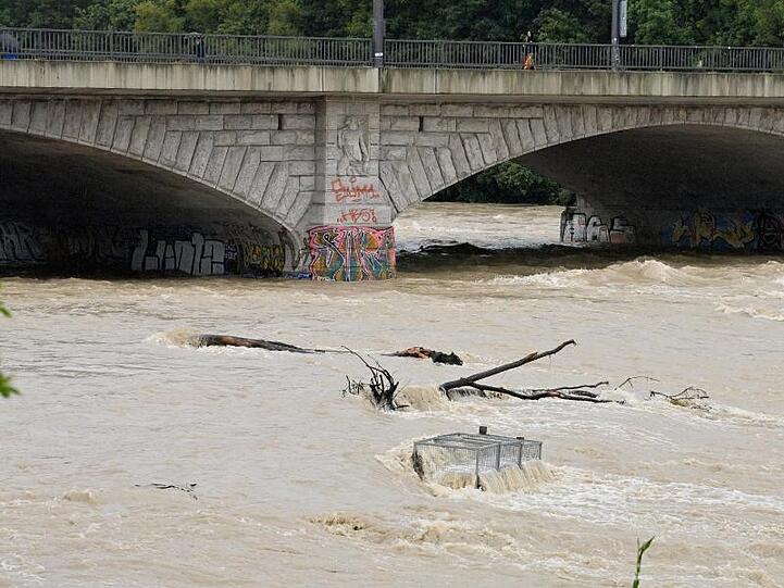 Nach starkem Regen fließt braunes Wasser unter der Reichenbachbrücke durch das Flussbett der Isar in München.