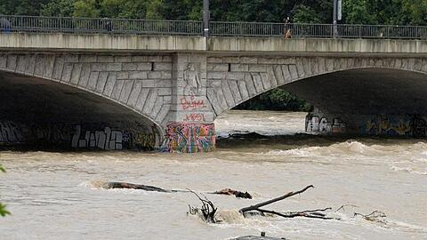 Nach starkem Regen fließt braunes Wasser unter der Reichenbachbrücke durch das Flussbett der Isar in München.