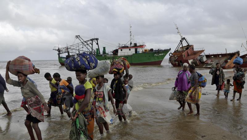 Familien kommen, nachdem sie 200 Kilometer vor Beira, aus einem überschwemmten Gebiet mit dem Boot gerettet wurden, am Strand an. Familien kommen, nachdem sie 200 Kilometer vor Beira, aus einem überschwemmten Gebiet mit dem Boot gerettet wurden, am Strand an.