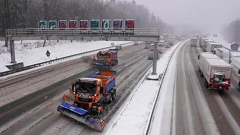 Fahrzeuge des Winterdienstes räumen auf der Autobahn 8 den Neuschnee weg.