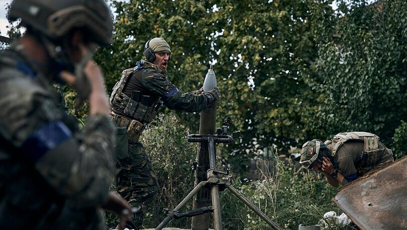Ukrainische Soldaten feuern einen Mörser in der kürzlich zurückeroberten Stadt Kupjansk in der Region Charkiw ab.