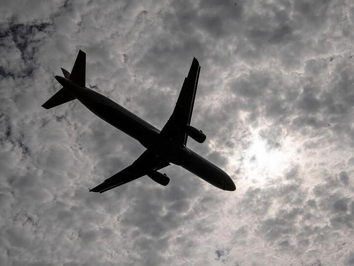 Ein Flugzeug fliegt an einem Wolkenfeld vorbei. Foto: Boris Roessler/Archivbild
