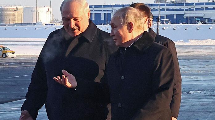 Wladimir Putin (r) wird bei seiner Ankunft auf dem Flughafen von Minsk von Alexander Lukaschenko empfangen.