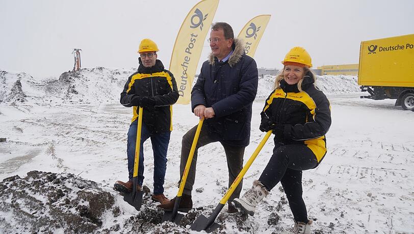Hier kommt die Halle hin): Thomas Schneider, Andreas Haas und Bettina Altschäffl (von links) beim Spatenstich der Post-Baustelle in Germering.