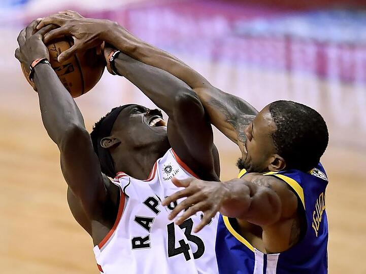 Pascal Siakam (l) von den Toronto Raptors im verteidigt den Ballbesitz gegen Andre Iguodala von den Golden State Warriors.