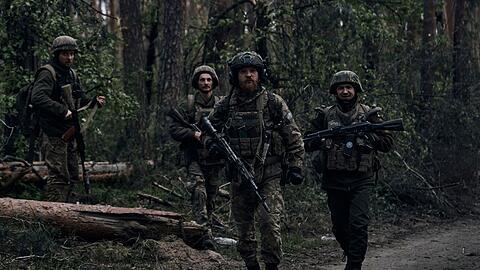 Ukrainische Soldaten gehen in der Nähe der russischen Stellungen in der Region Luhansk durch den Wald.