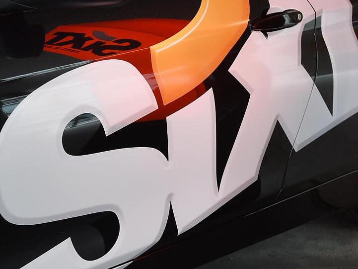 Das Logo des Autovermieters Sixt SE an einer Fahrzeugtür. Foto: Tobias Hase/dpa/Symbolbild