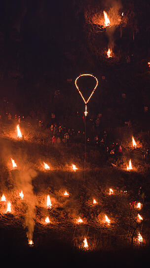 Beeindruckende Bilder: Zahlreiche Besucher stehen am Samstag nahe der Burg Pottenstein in der Stadt Pottenstein und blicken auf hunderte Bergfeuer. Grund ist das katholische Fest der Ewigen Anbetung.