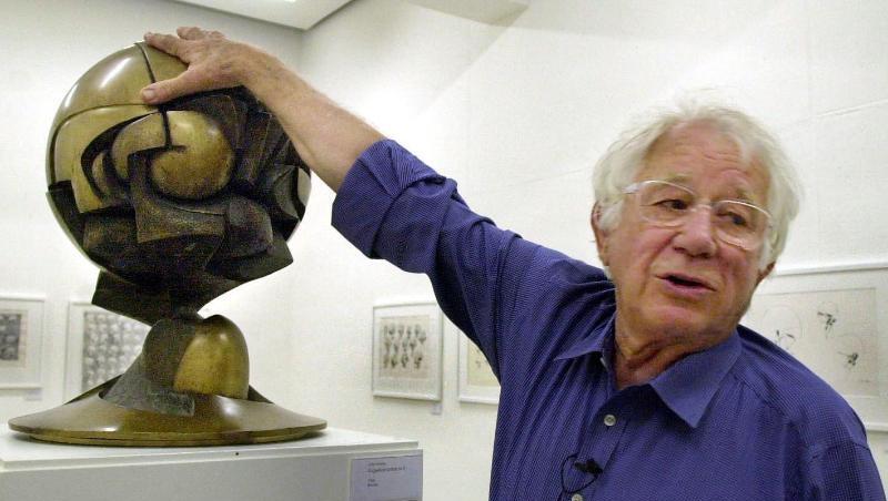 Der Bildhauer Fritz Koenig (1924-2017) legt seine Hand auf das Modell seiner Skulptur "The Sphere".
