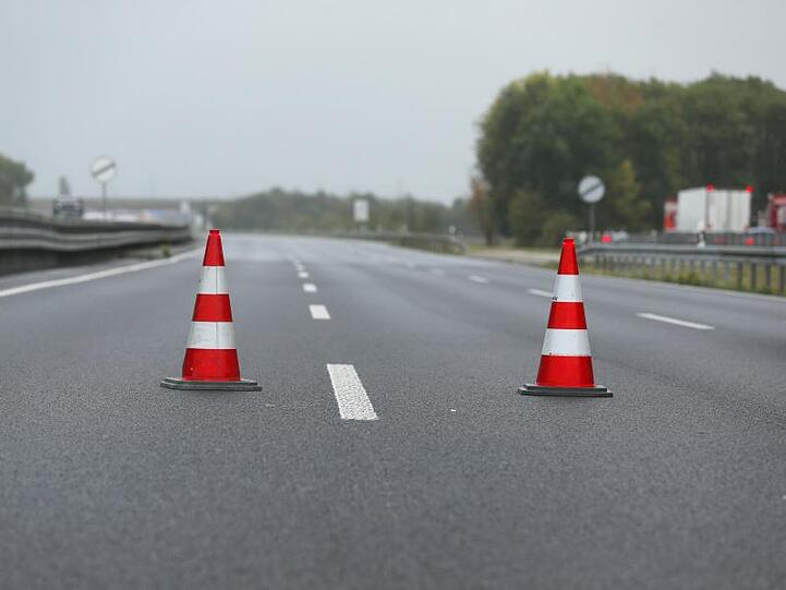 Zwei Verkehrshütchen stehen auf einer gesperrten Autobahn. Foto: David Young/dpa/Symbolbild