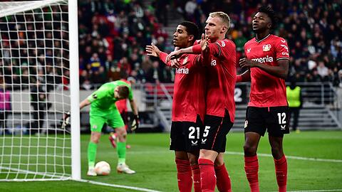 Leverkusens Torschütze Amine Adli (l-r) jubelt nach seinem Tor zum 0:2 mit Mitchel Bakker und Edmond Tapsoba.