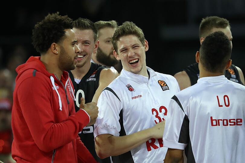 Die Bamberger Elias Harris (l-r), Daniel Theis und Patrick Heckmann jubeln über ihren Sieg.