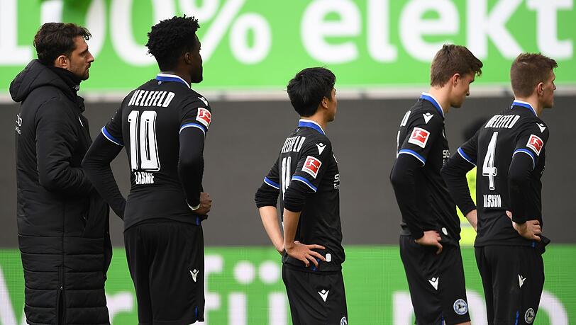 Nach dem 0:4 beim VfL Wolfsburg stehen die Spieler von Arminia Bielefeld mit gesenkten Köpfen auf dem Platz.