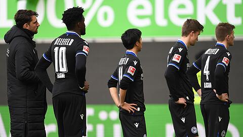 Nach dem 0:4 beim VfL Wolfsburg stehen die Spieler von Arminia Bielefeld mit gesenkten Köpfen auf dem Platz.