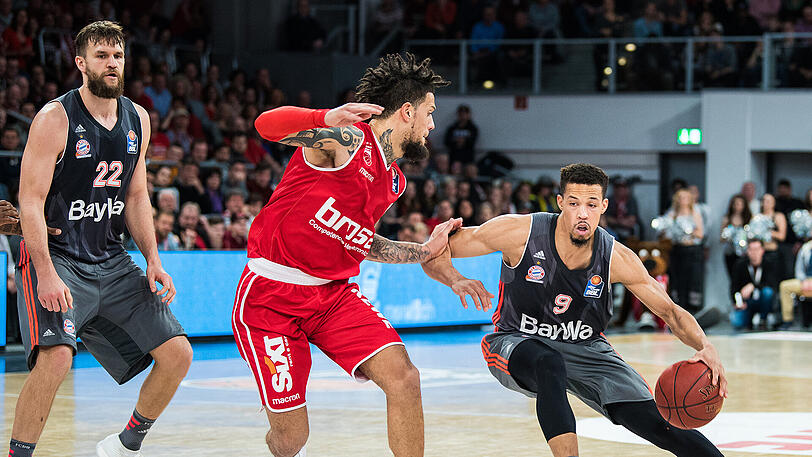 Bambergs Daniel Hackett (M) hat mit Bayern Münchens Jared Cunningham (r) seine Schwierigkeiten.