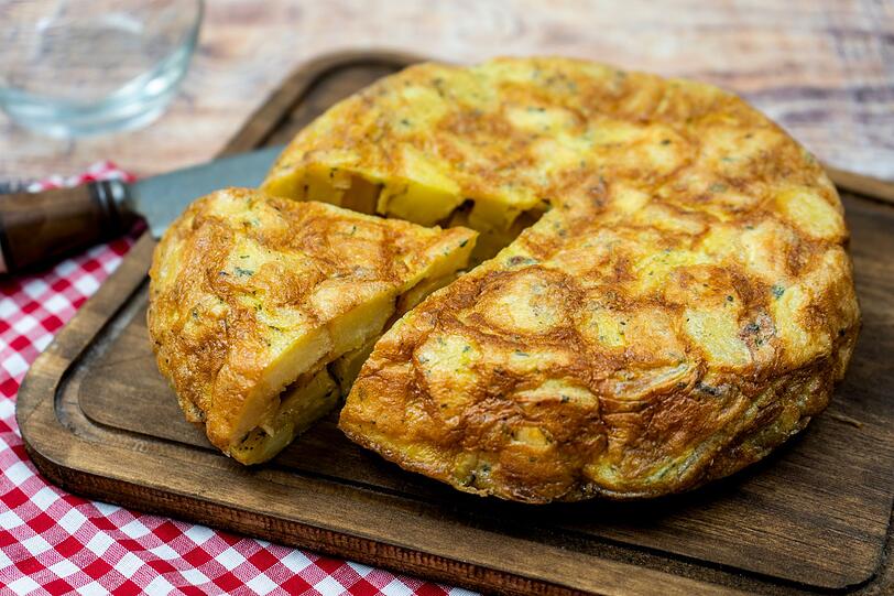 Mit gekochten Kartoffeln, die vielleicht von einer anderen Mahlzeit übrig geblieben sind, lässt sich ganz einfach eine Tortilla de Patatas zaubern. Das spanische Omelett wird aus Zwiebeln, Kartoffelstückchen und einer Eiermasse zubereitet. Nachdem das Gemüse in der Pfanne angebraten wurde, werden die verquirlten Eier darüber gegossen und entweder in der Pfanne gewendet oder einfach im Ofen fertig gebacken. Mit gekochten Kartoffeln, die vielleicht von einer anderen Mahlzeit übrig geblieben sind, lässt sich ganz einfach eine Tortilla de Patatas zaubern. Das spanische Omelett wird aus Zwiebeln, Kartoffelstückchen und einer Eiermasse zubereitet. Nachdem das Gemüse in der Pfanne angebraten wurde, werden die verquirlten Eier darüber gegossen und entweder in der Pfanne gewendet oder einfach im Ofen fertig gebacken.