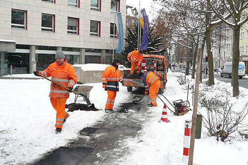 Stadt-Mitarbeiter flicken die Gehwege notdürftig.