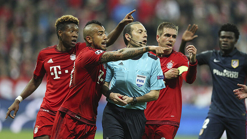 Die Bayern diskutieren während des Spiels gegen Atlético Madrid mit Schiedsrichter Cüneyt Cakir.