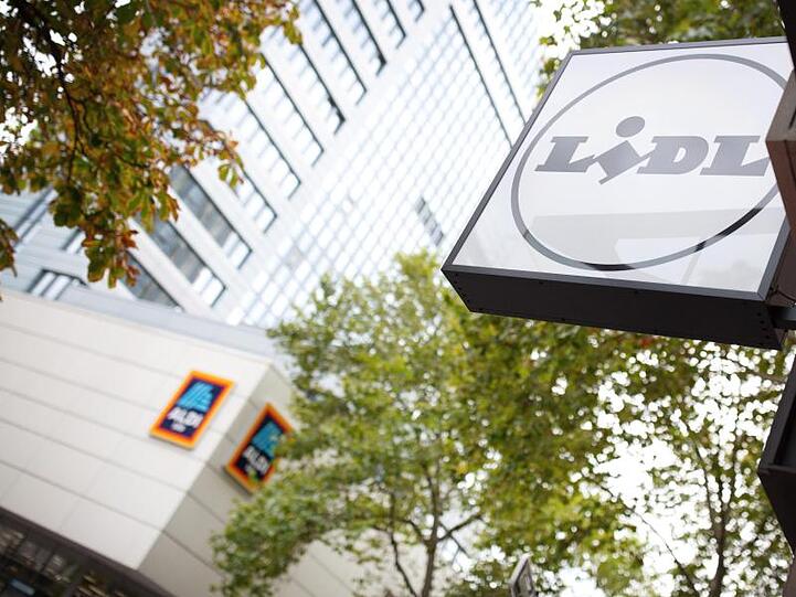 Das Logo des Discounters Lidl hängt gegenüber dem Logo von Aldi an der Königsallee in Düsseldorf.