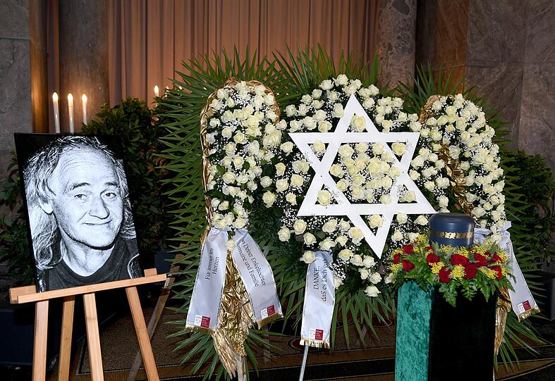 Abschied in München: Das Porträt von Wolfgang Nöth, daneben die Urne, Rosenkränze und ein Davidstern.