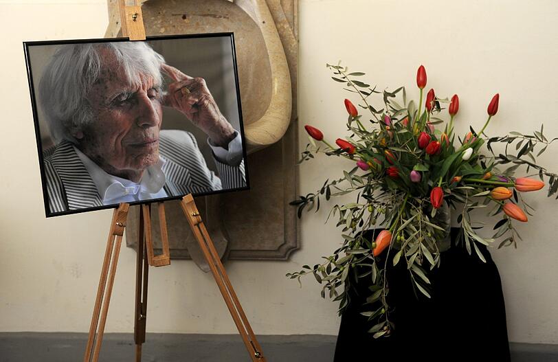 Ein Porträt von Johannes Heesters und ein Strauß Tulpen stehen am Freitag am Nordfriedhof....