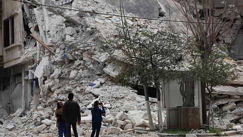 Menschen stehen vor den Trümmern eines Gebäudes, das bei dem jüngsten Erdbeben in Aleppo zerstört wurde.
