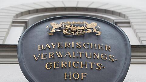 Ein Schild mit der Aufschrift "Bayerischer Verwaltungsgerichtshof" hängt an der Fassade des Gebäudes. Foto: picture alliance / Peter Kneffel/dpa/Archivbild