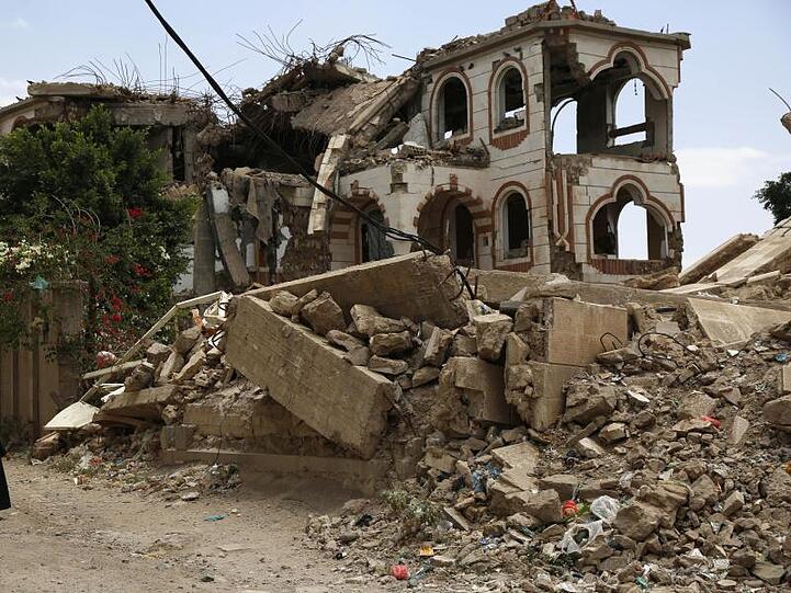 Ein Kind steht vor einem zerstörten Haus in der jemenitischen Hauptstadt Sanaa.