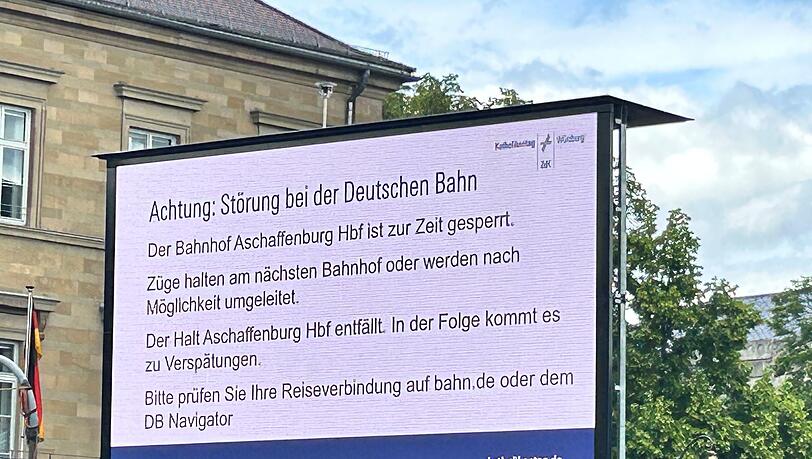 Ein Hinweis macht die Besucher des Katholikentags in W&uuml;rzburg auf die wenig sp&auml;ter aufgehobene Sperrung des Bahnhofs in Aschaffenburg aufmerksam.