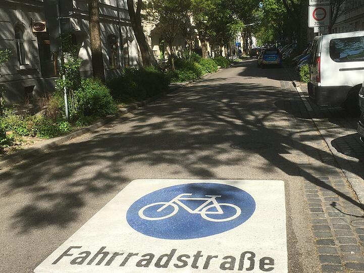 Ein großer Hinweis auf dem Asphalt signalisiert, dass hier Fahrräder Vorrang haben.