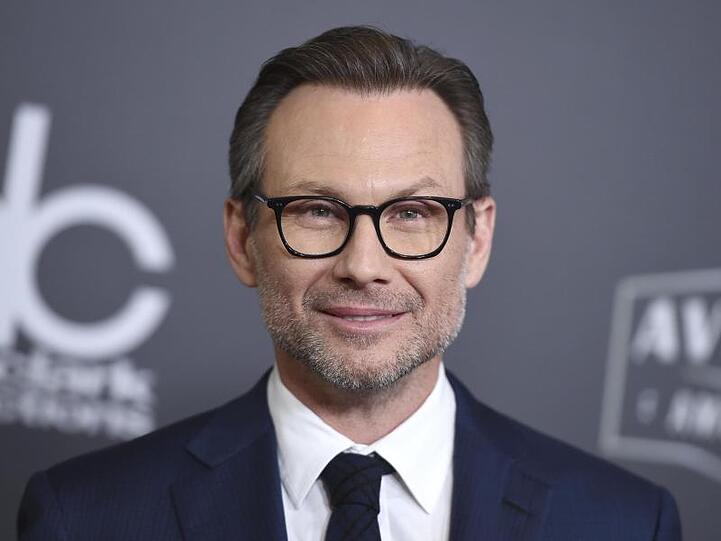 Christian Slater freut sich über ein Mädchen.