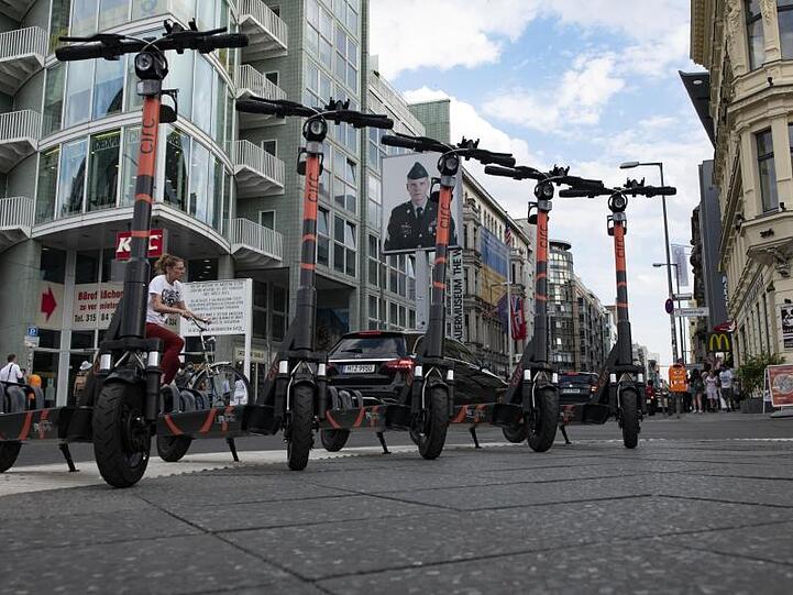 Bestes Testgebiet zum Auftakt: Am von Touristen umlagerten Checkpoint Charlie in Berlin warten E-Tretroller auf die ersten Nutzer.
