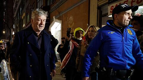 Alec Baldwin (l.) wird von NYPD-Beamten von der Demonstration weg eskortiert.