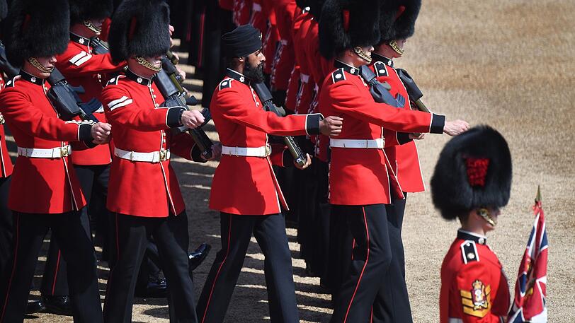 Mitglieder der Coldstream-Garde, darunter auch Charanpreet Singh Lall mit Turban, marschieren für die Queen.