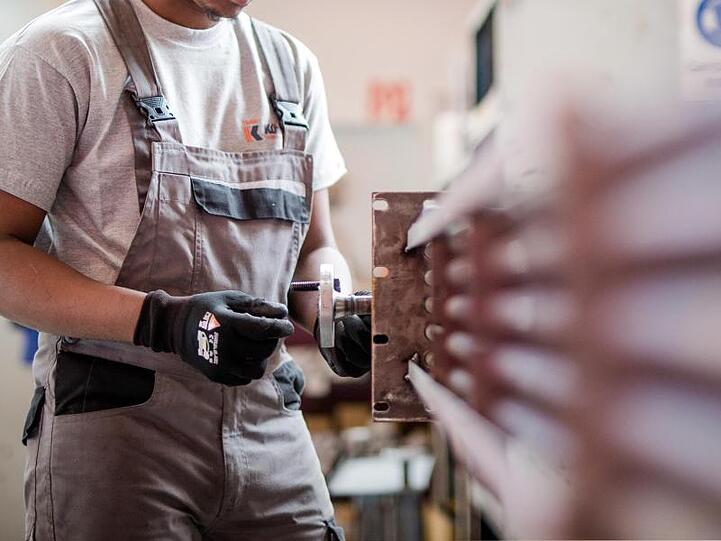 Ein Praktikant arbeitet bei einem Industrieunternehmen in der Produktion an einem Wärmetauscher. Foto: Christoph Schmidt/dpa/Archivbild